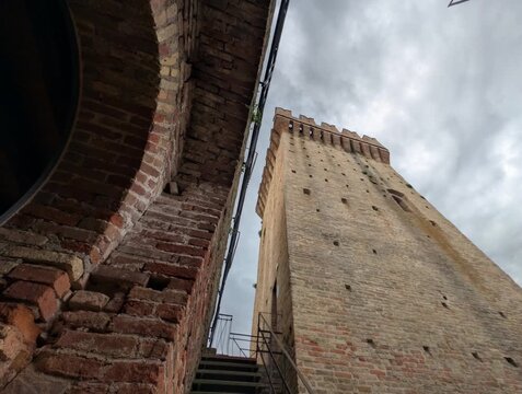 Imponente castello in pietra con torri merlate e mura storiche sotto un cielo grigio, per un&rsquo;atmosfera medievale forte e suggestiva