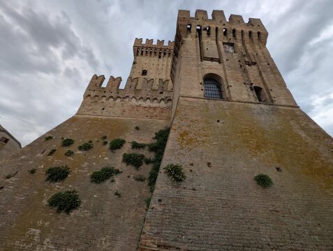 Imponente castello in pietra con torri merlate e mura storiche sotto un cielo grigio, per un&rsquo;atmosfera medievale forte e suggestiva
