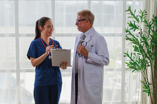 Medical doctor and nurse practitioner collaborating on patient consultations and treatment plans in a bright clinic, smiling and communicating as a professional healthcare team