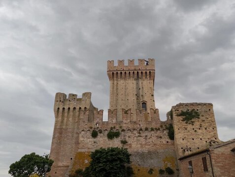 Imponente castello in pietra con torri merlate e mura storiche sotto un cielo grigio, per un&rsquo;atmosfera medievale forte e suggestiva