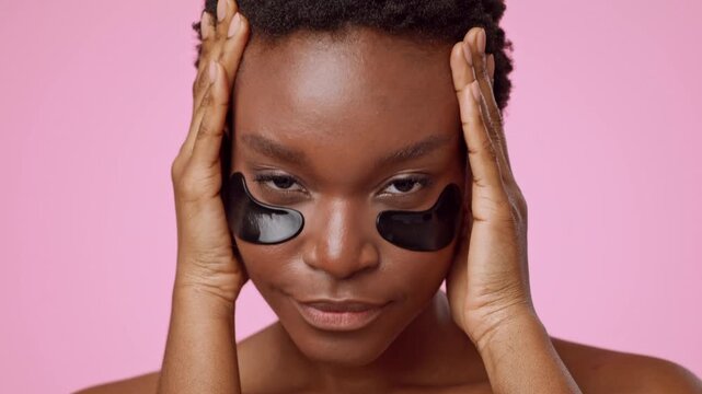 Focused Young Black Woman Applying Under Eye Patches As Part Of Skincare Routine At Home. Taking Care Of Skin While Relaxing In A Comfortable Indoor Setting. Self-care Concept
