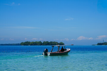 Obraz premium Small motorboat floating on clear turquoise water near Sepa Island, Indonesia.