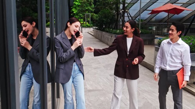 Three professionals meet on an outdoor office terrace; two shake hands while a colleague with a folder looks on, suggesting a successful business meeting.