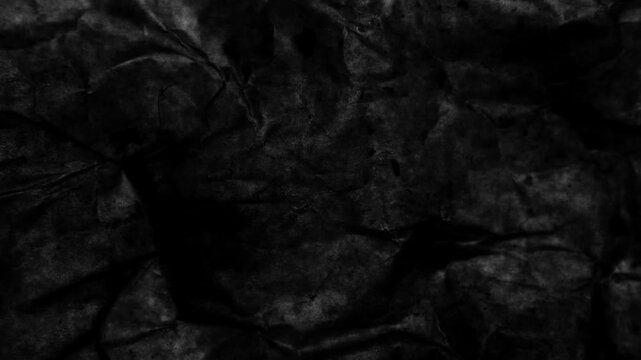 Dark, dynamic texture of crumpled paper. 4K