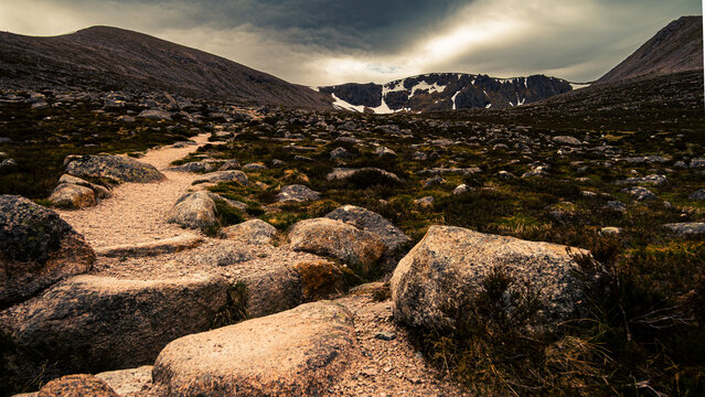 Mountain Trail Through Boulder Field Toward Snow-Capped Corrie, Cairngorms Scotland