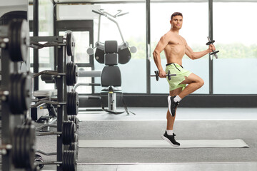 Fototapeta premium Shirtless muscular man exercising with dumbbells and jumping