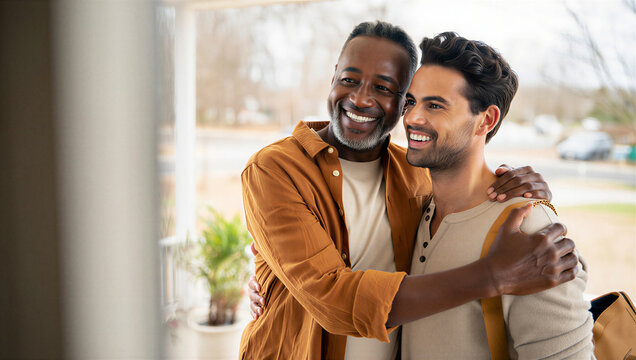 Proud father sharing a joyous send-off embrace with his young adult son departing for a new life adventure.