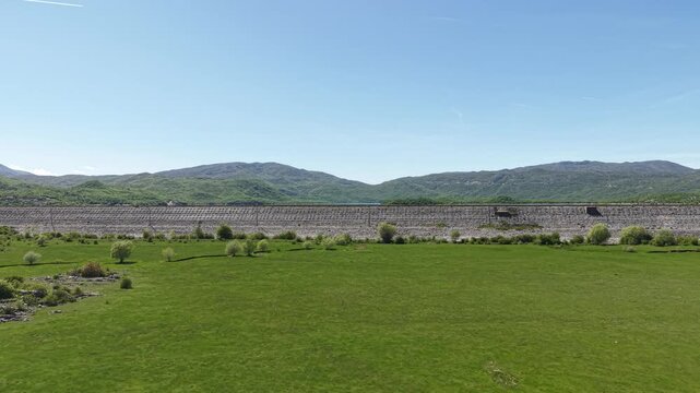 Slano Lake, Montenegro. Revealing Drone Shot of Water Reservoir Above Dam and Green Pastures on Sunny Summer Day