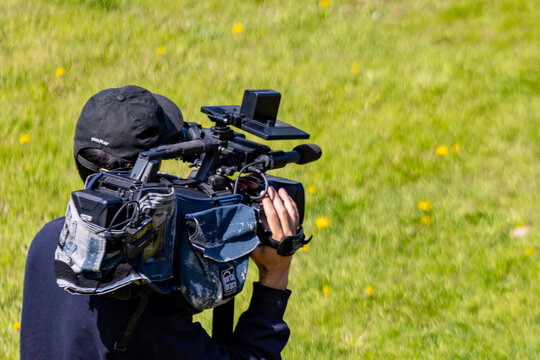 Gaspesie, Canada, 01 June 2026 : A videographer operates a professional video camera with a Porta Brace bag outdoors.