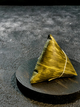 Bacang is a traditional Chinese food wrapped in bamboo leaves in a triangular pyramid shape filled with glutinous rice with soy sauce pork or chicken, salted egg, and sometimes mushrooms or peanuts.