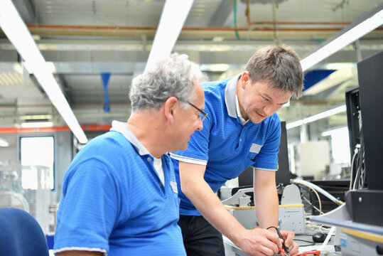 teamwork in a modern industrial factory - group of workers in the production and development of electronics