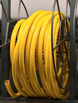 Yellow flexible hose arranged in a circular coil is shown on store shelving in a building materials supermarket