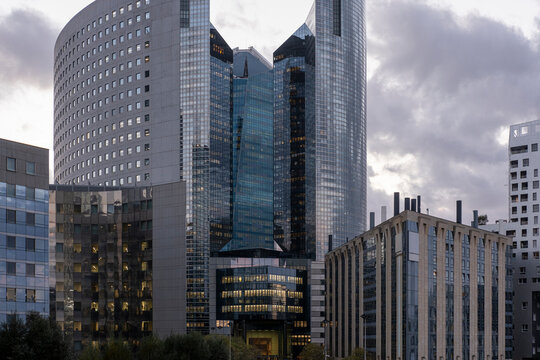 A layered skyline in Paris, France shows architecture, tower, glass office blocks, business facade and corporate buildings in La Defense beneath clouds