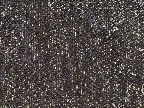 Close up texture of black boucle fabric. Curled and nubby knitted tufted texture. Suitable for sofa, upholstery, curtain, and drapery. Seamless background fabric texture.