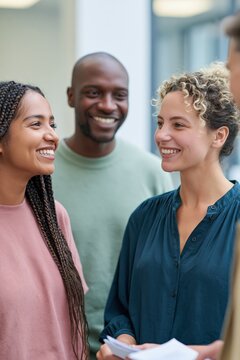 Three smiling coworkers conversing in office discussion for team meeting banner and workplace communication background