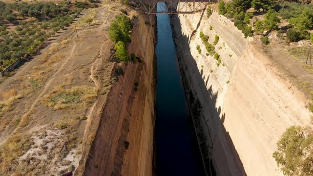 Aerial view of Corinth Canal canal in Greece that connects the Gulf of Corinth in the Ionian Sea with the Saronic Gulf in the Aegean Sea. Drone view from above. 
