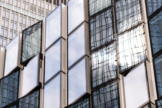 Glass facade windows and reflection across panels create geometry, contrast and business architecture over a layered surface of mirrored edges
