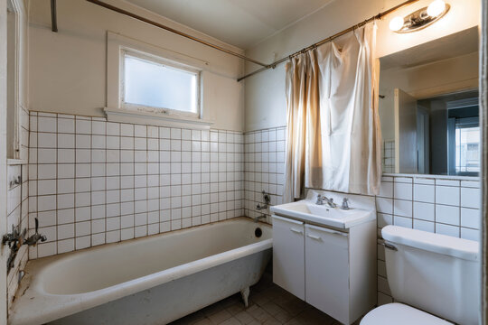 An outdated bathroom with classic fixtures shows signs of wear and age, highlighting the need for modern updates and renovation to create a more functional and appealing space.