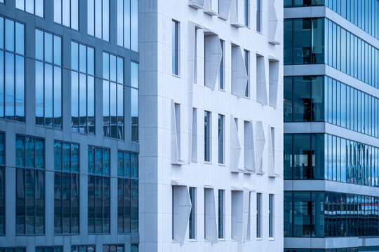 Blue glass buildings layer facade windows and architecture, creating urban office business contrast across clean corporate surfaces