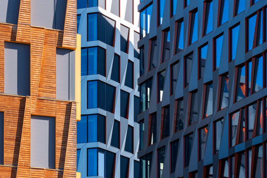 Color contrast between glass facade windows turns architecture and building pattern into a sharp urban business composition of blue and orange surfaces