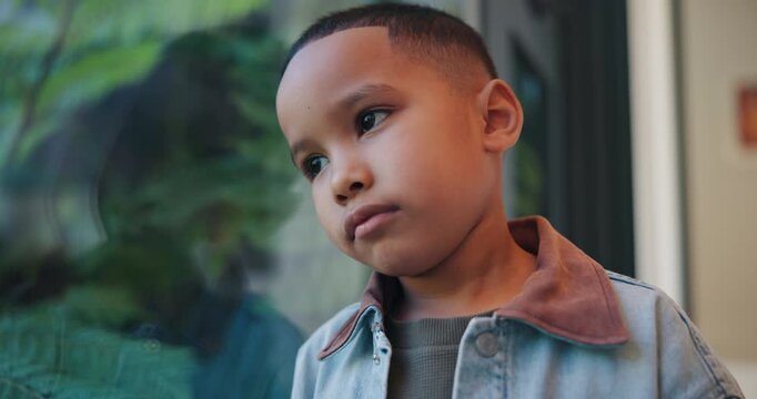 Reflection, sad and boy by window in home thinking of trauma, bad memory and loneliness. House, childhood and child with thoughtful, wondering and upset emotions for separation, alone and worry