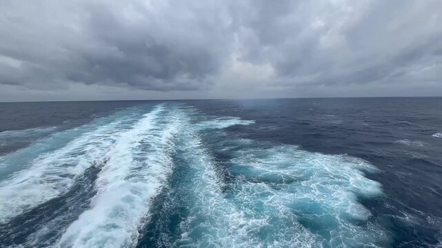 Unedited 1080 footage from the stern of a cruise liner on a transatlantic crossing. Dark blue ocean, overcast sky, and the ship's foamy wake. Original audio: ocean waves mixed with propeller rumble.