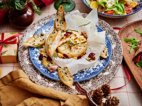 Roasted lemon slices with rosemary and walnuts on a decorative plate, festive table setting, seasonal dining concept