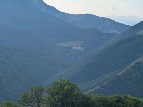 Panorama montano con il Monastero di Fonte Avellana immerso tra colline verdi e vallate boscose, in un&rsquo;atmosfera naturale, silenziosa e contemplativa