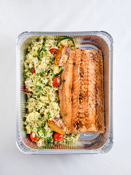 Baked salmon fillet with quinoa salad and grilled vegetables, meal prep container for healthy eating promotion