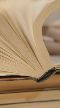 a book with pages turning. The book has a soft cover and the text is not visible.