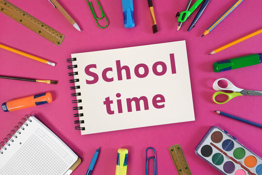 School time writing on Plain Notebook. Back to School concept or education, Schedule. Welcome inscription of preschool, beginning of school year. pens, pencils, paints, markers on a pink background