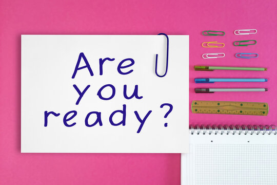 Are you ready. Handwritten text in white sheet with paper clip. Plain Paper with text against background of school or office on desktop. flat lay. Concept Back to School and studying. Business life