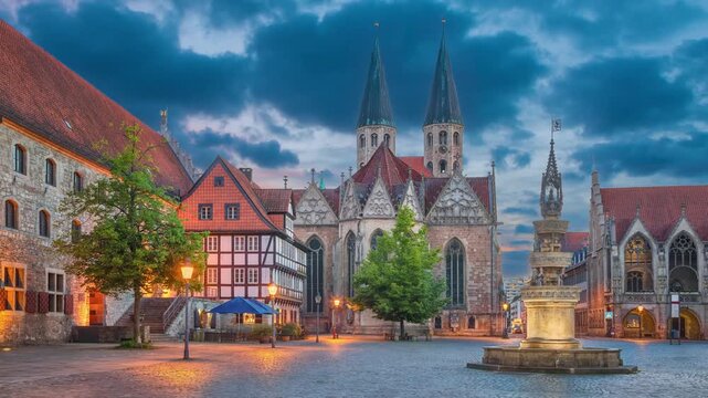 Braunschweig, Germany - view of Altstadtmarkt square at dusk with church of St. Martin and Marienbrunnen fountain (static image with animated sky)