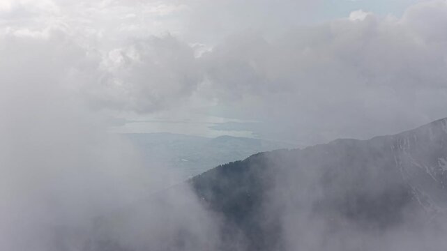 Aerial descend Swiss alpine valley behind clouds Switzerland Glarus region