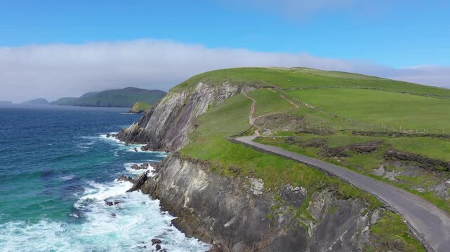 A narrow road winds along steep cliffs overlooking the Atlantic Ocean. Ideal for travel or landscape projects.