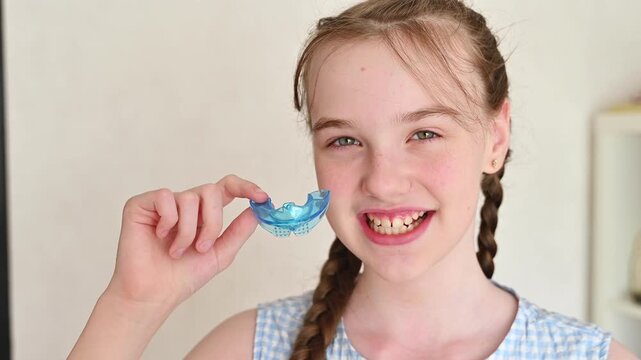 Little girl holding silicone dental bite trainer