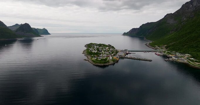Husoy island fishing village connected to Senja with causeway in Oyfjord, drone