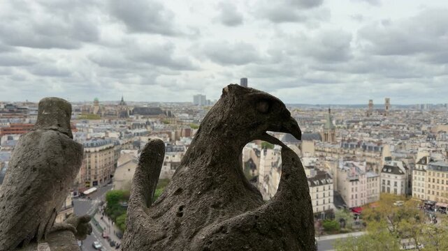 Famous gargoyle chimera statue on top of Notre Dame de Paris Cathedral observing the city of Paris on a cloudy day, a popular landmark and tourist attraction for a France vacation