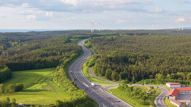 Drone shot of Autobahn A9 near Trockau, Bavaria, with highway traffic, green countryside, and transportation infrastructure in Germany during a sunny summer day, UHD.