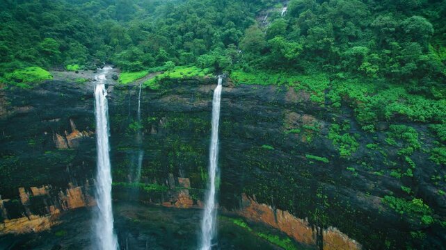 4K Aerial view of majestic Kataldhaar waterfall flowing from cliff during rainy day in Sahyadri Hills, Maharashtra, India. Green trees in forest hill and waterfall flowing in valley. Nature monsoon la