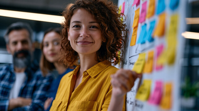 Nonprofit communications team gathered around a whiteboard mapping a cause marketing campaign strategy, diverse group annotating donor audience segments and impact storytelling pillars on a large sh