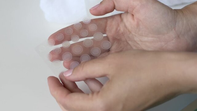 Minimal close-up of transparent hydrocolloid acne patches prepared for skincare routine. Concept of invisible blemish treatment, Korean beauty and modern dermatology products.