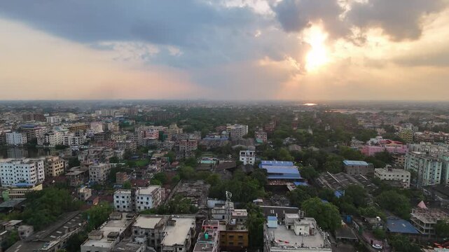 A stunning high-altitude view of the Kolkata skyline shrouded in soft monsoon clouds, highlighting the contrast between heritage architecture and modern urban expansion.