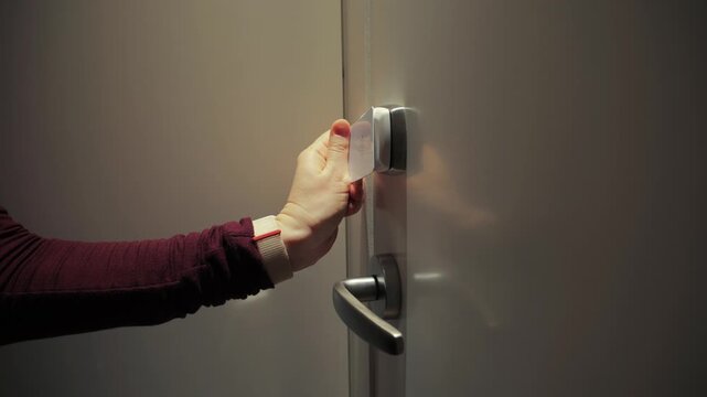 A close-up of a hand touching a hotel key card to open a room. Contactless access highlights modern security technologies and convenience in the hospitality industry. Conceptualization of travel