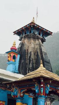 Beautiful view of Omkareshwar Temple in Ukhimath, Uttarakhand, featuring colorful pillars and traditional Himalayan architecture surrounded by mist-covered mountains.