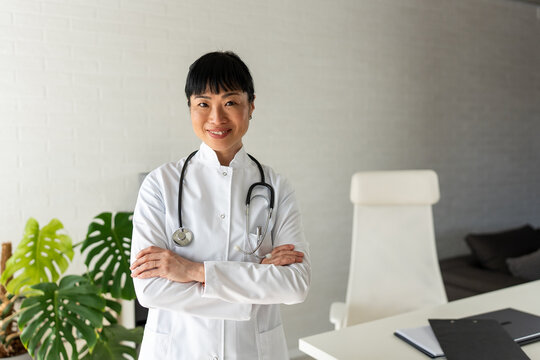 Experienced female physician posing confidently in medical office. Healthcare leadership, professional success, medical expertise and trust concept