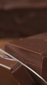 Sharp blade cutting cocoa chocolate dessert perfect for food blogs, recipe websites, or social media posts related to desserts.