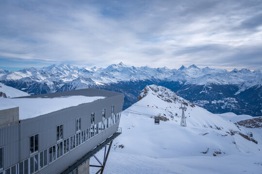 Scenic view from top station of Funitel Violettes-Plaine Morte in Crans-Montana, Switzerland over Rhone Valley towards Weisshorn and Matterhorn against blue sky with clouds