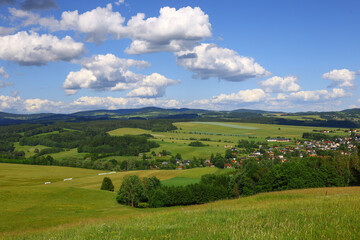 Obraz premium central european foothill landscape in the czech republic with open grassland, clustered village structures and rolling terrain