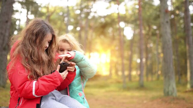 Two little girls playing with cell phone